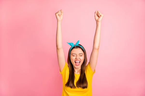 Ritratto di adolescente entusiasta con gli occhi chiusi alzando i pugni urlando sì indossando una t-shirt gialla isolata su sfondo rosa — Foto Stock