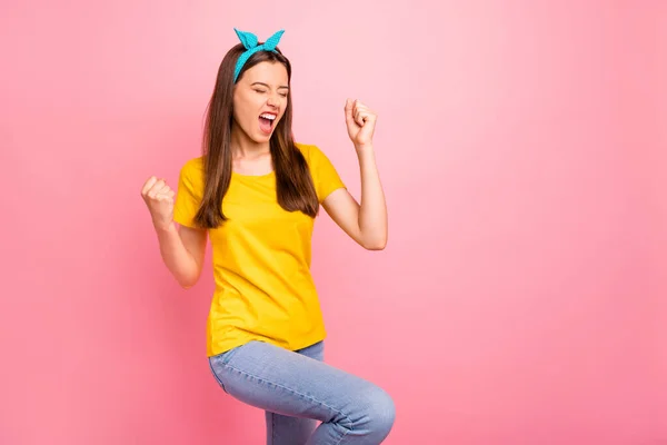 Portret wesołej młodości podnoszącej pięści krzycząc tak nosząc żółty t-shirt odizolowany na różowym tle — Zdjęcie stockowe