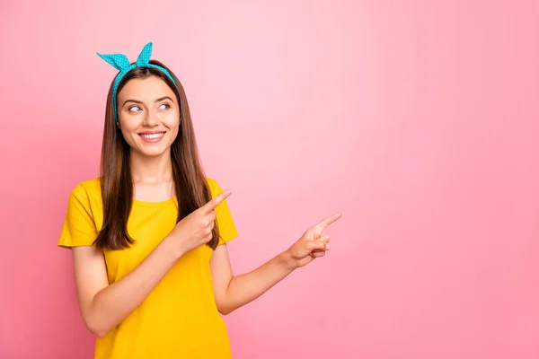 Portrait de dame attrayante montrant la promotion avec son doigt regardant porter t-shirt jaune isolé sur fond rose — Photo