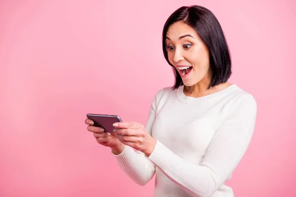 Profiel foto van verbazingwekkende dame met telefoon lezen positieve reacties op nieuwe post slijtage witte trui geïsoleerde roze kleur achtergrond — Stockfoto
