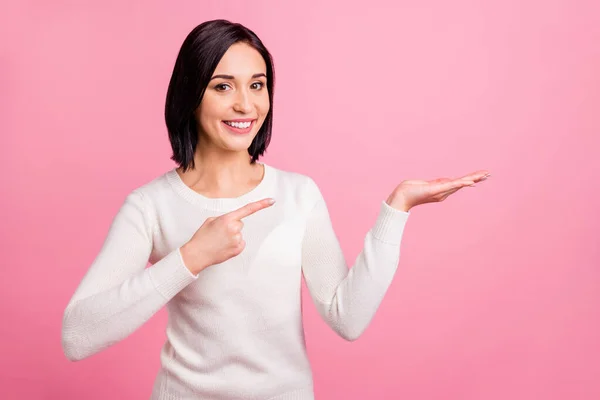 Foto di bella signora d'affari indicando dito sul palmo aperto che presenta novità usura pullover bianco isolato rosa sfondo di colore brillante — Foto Stock