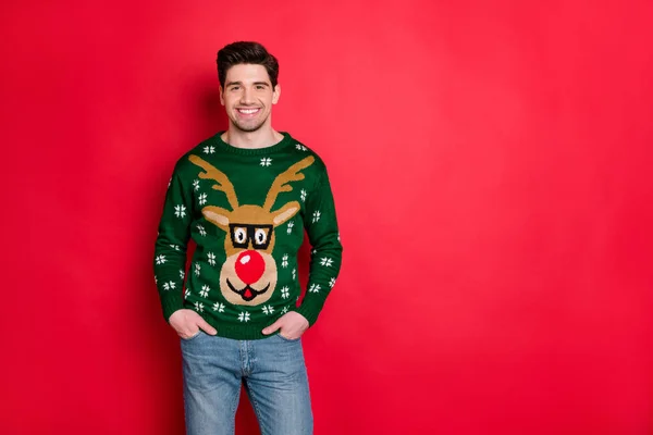 Porträt von gut aussehenden zufriedenen Mann tragen Hirsch Rentier Pullover genießen Thema Weihnachtsfeier isoliert über rote Farbe Hintergrund — Stockfoto