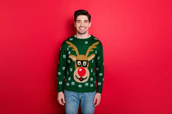 Retrato de charmoso engraçado homem funky em veados pulôver confortável desfrutar de festa de Natal mascarada isolado desgaste jeans jeans isolado sobre fundo de cor vermelha — Fotografia de Stock