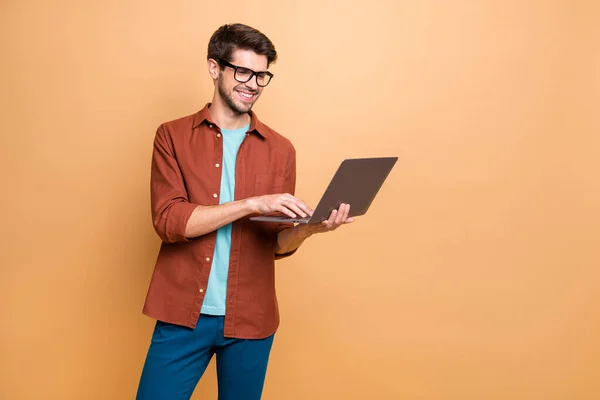 Portrait of his he nice attractive cheerful cheery successful smart clever intelligent brunet guy consultant agent broker holding in hands laptop isolated over beige color pastel background — ストック写真