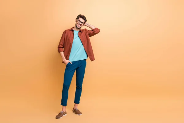 Longitud completa cuerpo tamaño vista de su él agradable atractivo moda alegre alegre morena chico macho hipster posando tocando pelo aislado sobre color beige pastel fondo — Foto de Stock