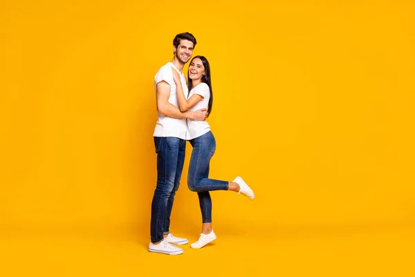 Полноразмерная фотография удивительной пары, держащей друг друга в руках первый урок танца пары в повседневном наряде на изолированном желтом фоне — стоковое фото