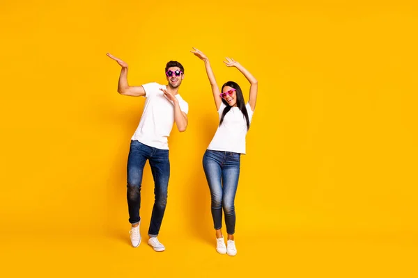 Full length photo of two crazy people dancing at first season theme party wear cool specs and casual clothes isolated yellow color background — Stock fotografie
