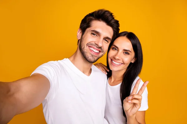 Foto van twee mensen nemen selfies tonen v-teken zeggen hoi aan alle volgelingen dragen casual kleding geïsoleerde gele kleur achtergrond — Stockfoto