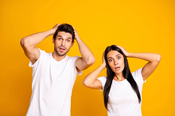 Foto av trevligt par som håller händerna på huvudet inte tror dåliga nyheter bära casual vita t-shirts isolerad gul färg bakgrund — Stockfoto