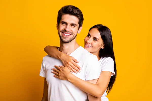 Foto de pareja increíble en el amor postura a cuestas perdieron el uno al otro feliz de estar finalmente juntos llevar casual blanco camisetas aisladas de color amarillo de fondo — Foto de Stock