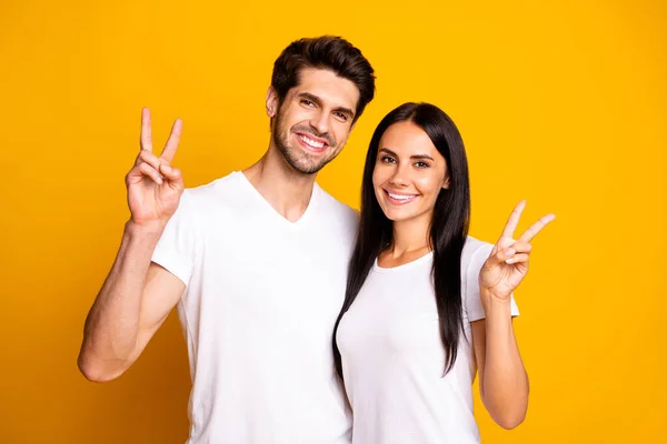 Foto de casamento incrível par mostrando símbolos v-sinal desgaste casual roupa isolado cor amarela fundo — Fotografia de Stock