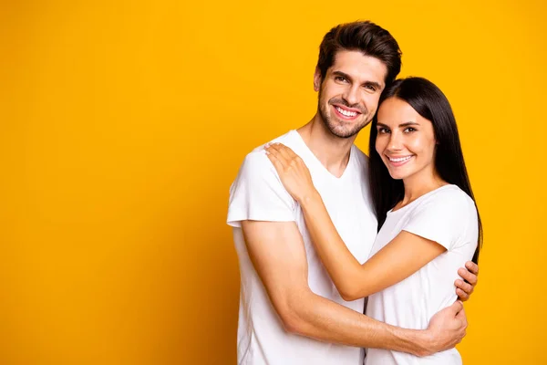 Szczęśliwi razem. Zdjęcie niesamowitej pary w miłości przytulanie nosić casual biały t-shirty odizolowany żółty kolor tła — Zdjęcie stockowe