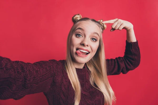 Foto de primer plano de la señora bonita divertido peinado haciendo selfies dirigir el dedo en bollos fríos desgaste borgoña jersey de punto aislado pastel fondo de color rojo —  Fotos de Stock