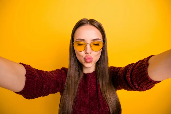 Photo rapprochée de belle fille en lunettes de vue envoyant des baisers d'air fermant les yeux portant un pull marron isolé sur fond jaune — Photo