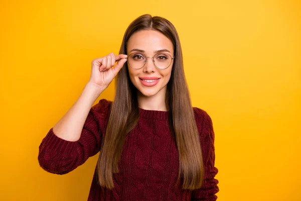 Retrato de la encantadora dama tocando sus gafas sonriendo usando jersey de marsala aislado sobre fondo amarillo —  Fotos de Stock