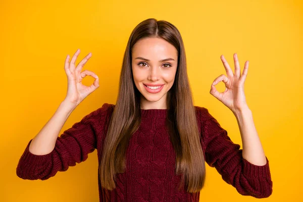 Close up photo of lovely lady showing ok signs smiling wearing maroon jumper isolated over yellow background — ストック写真