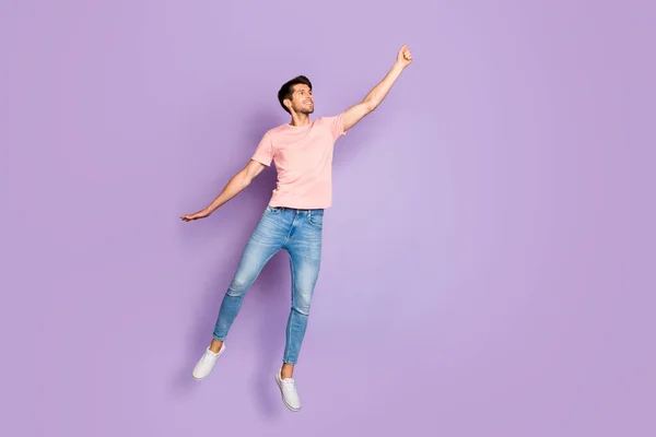 Full size foto van geweldige kerel springen en vliegen hoog met denkbeeldige paraplu dragen casual outfit geïsoleerd op paarse kleur achtergrond — Stockfoto