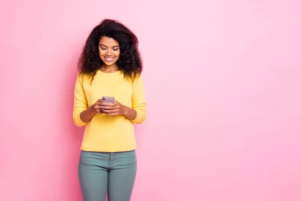 Portrait of cheerful positive interested black girl hipster use her phone comment posts enjoy blogs blogger wear good looking stylish lifestyle clothes isolated over pink color background — ストック写真