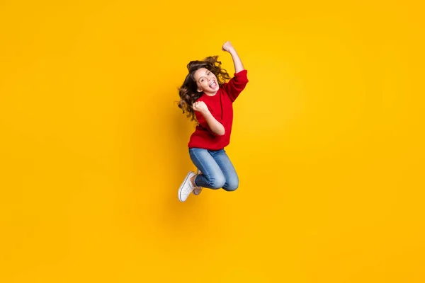 Foto de comprimento total de engraçado pequena senhora saltando alto celebrando brinquedos do ano novo preços de venda compras desgaste vermelho de malha pulôver isolado fundo amarelo — Fotografia de Stock