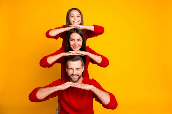 Foto de funky alegre agradable linda familia encantadora que forma la pirámide poniendo las manos sobre las cabezas de los demás creando copyspace aislado sobre el fondo de color vibrante —  Fotos de Stock