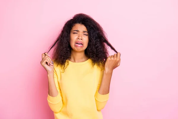 Retrato de niña africana infeliz negativa mira su cabello seco dañado grito sentir miseria sobre el nuevo tratamiento de salón terapia anticaspa caspa desgaste jersey amarillo aislado sobre fondo de color pastel —  Fotos de Stock