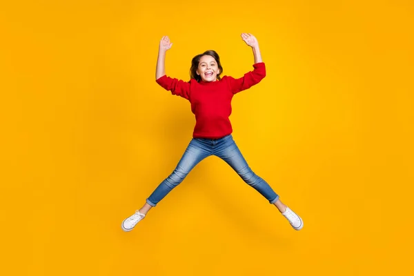 Full body photo of excited little lady jumping high in star shape celebrating newyear toys sale prices shopping wear red knitted pullover isolated yellow background — ストック写真