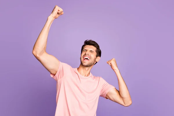 Portret van zijn hij mooi aantrekkelijk sportief gespierd vrolijk vrolijk blij tevreden man dragen roze tshirt vieren prestatie vakantie geïsoleerd op violet paars lila pastel kleur achtergrond — Stockfoto
