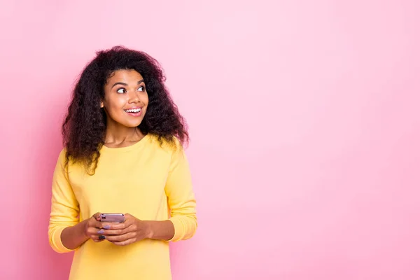 Portrait de choqué excité fille africaine utiliser son téléphone portable ont notification de blogueur célèbre se sentent fou porter tenue bon look isolé sur fond de couleur rose — Photo