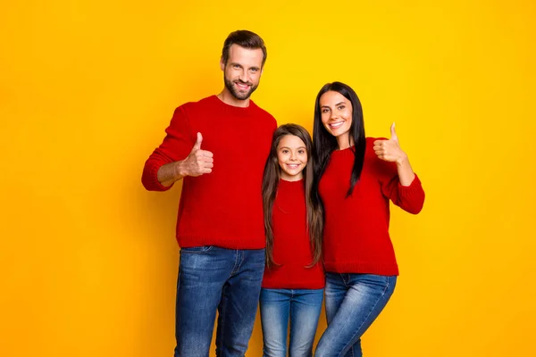 Foto de alegre bonito encantador agradável família funky com mãe pai e filha mostrando-lhe polegares para cima vestindo jeans jeans isolado sobre cor viva fundo amarelo — Fotografia de Stock