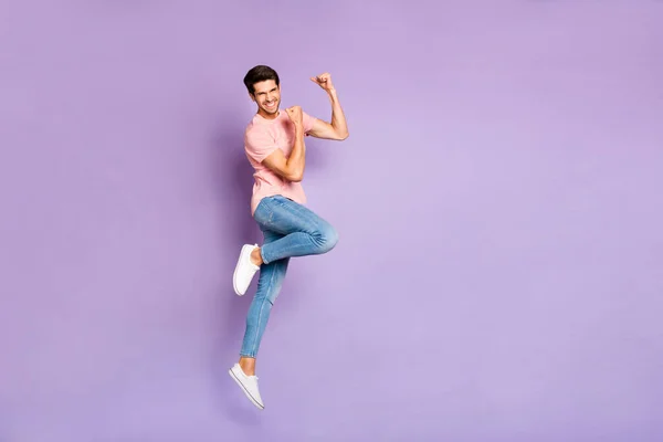 Full längd foto av fantastisk kille hoppar högt på sport tävlingar som stöder favorit lag bära casual outfit isolerad på lila färg bakgrund — Stockfoto