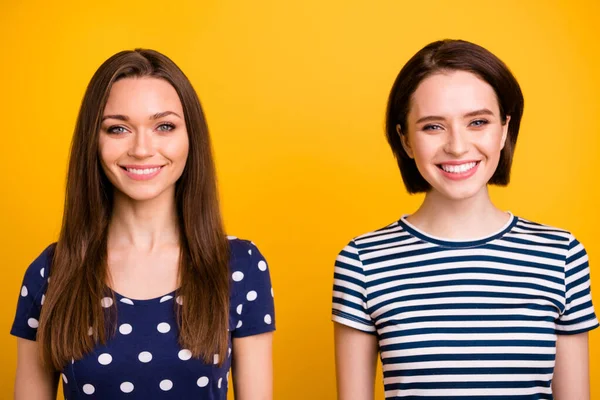 Κοντινή φωτογραφία από δύο καταπληκτικές θετικές κυρίες με υπέροχο ακτινοβόλο χαμόγελο σε καλή διάθεση φορούν καλοκαιρινά casual t-shirts απομονωμένο κίτρινο φόντο — Φωτογραφία Αρχείου