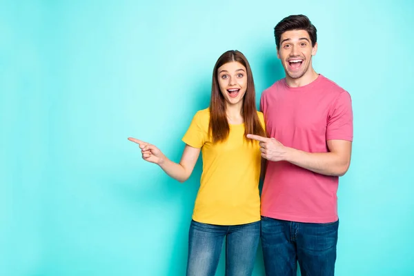 Portrait of his he her she nice attractive lovely cheerful cheery ecstatic glad couple hugging pointing aside ad advert good news isolated over bright vivid shine vibrant green turquoise background — Stock Photo, Image