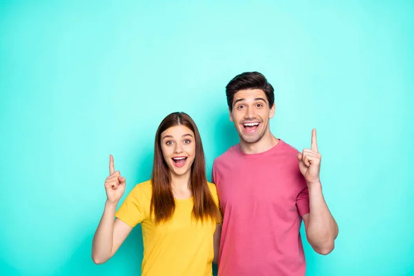 Retrato dele ele ela agradável atraente encantador agradável alegre casal abraçando apontando para cima anúncio novas dicas feedback isolado sobre brilhante brilho vívido vibrante verde turquesa fundo — Fotografia de Stock