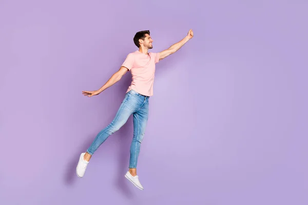 Pleine longueur photo de gars drôle sautant et volant haut avec parapluie imaginaire porter tenue décontractée isolé sur fond de couleur pourpre — Photo