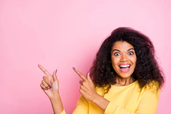Close up photo of funny shocked African girl promoter enjoy ads recommend black friday pick tips point index finger wear finger wear yellow sweater isolated over pastel color background — Fotografia de Stock