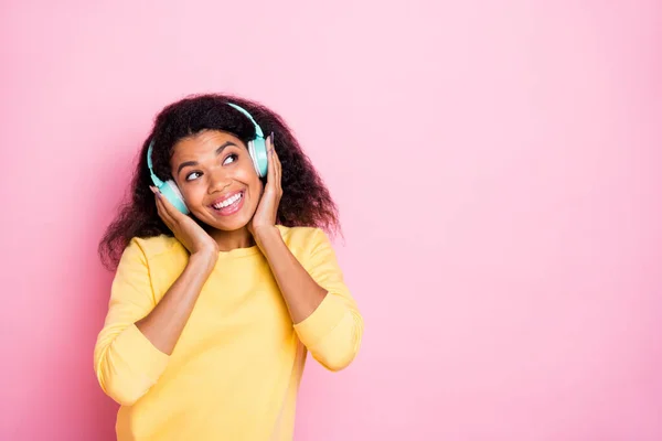 Portret van vrolijk schattig Afrikaans meisje luisteren muziek lied radio op haar oortjes genieten pauze pauze vrije tijd dragen gele lifestyle trui trui geïsoleerd over pastel kleur achtergrond — Stockfoto