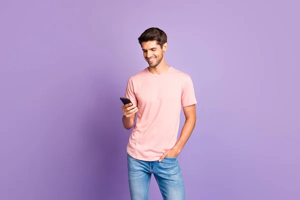 Retrato de su bonito atractivo alegre alegre alegre chico usando camiseta rosa en las manos usando 5g aplicación celular aislado sobre violeta púrpura lila pastel color fondo — Foto de Stock