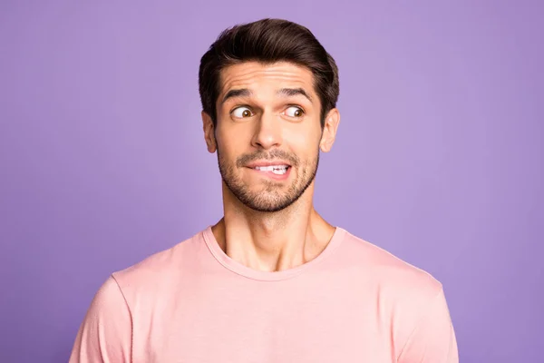 Close-up portret van zijn hij mooi leuk grappig verwarde brunet bebaarde man dragen roze tshirt wachten nieuws bijten lip geïsoleerd over violet paars lila pastel kleur achtergrond — Stockfoto