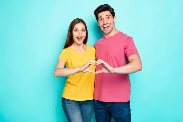 Portrait of his he her she nice attractive lovely charming positive excited cheerful cheery couple hugging showing heart symbol isolated over bright vivid shine vibrant green turquoise background — Stock Photo, Image