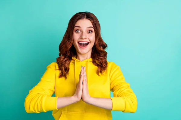 Foto de alegre linda y encantadora novia fascinante rogándole que diga la oración con la expresión facial extática manos plegadas aisladas sobre el fondo de color verde azulado — Foto de Stock