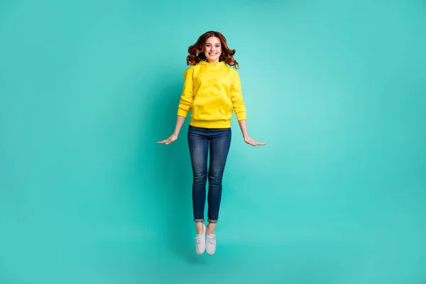 Comprimento total do corpo tamanho foto de alegre agradável bonito doce bonita namorada esticando-se pulando em calçados jeans denim isolado sobre fundo de cor turquesa vívida — Fotografia de Stock