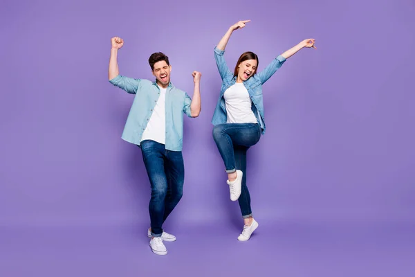 Full size foto van grappige gekke echtgenoten voelen geluk vieren overwinning op huwelijksreis weekend verhogen vuisten schreeuwen ja dragen goed uitziende outfit sneakers geïsoleerd over violet paarse kleur achtergrond — Stockfoto