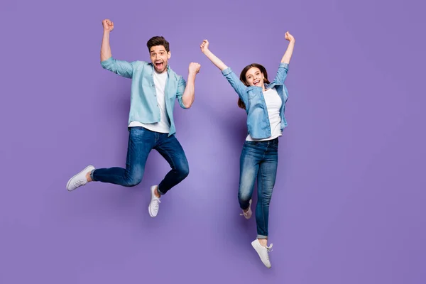 Volledige foto van vrolijke grappige funky studenten springen echtgenoten verhogen vuisten schreeuwen ja dragen moderne kleding witte sneakers geïsoleerd over violet paarse kleur achtergrond — Stockfoto