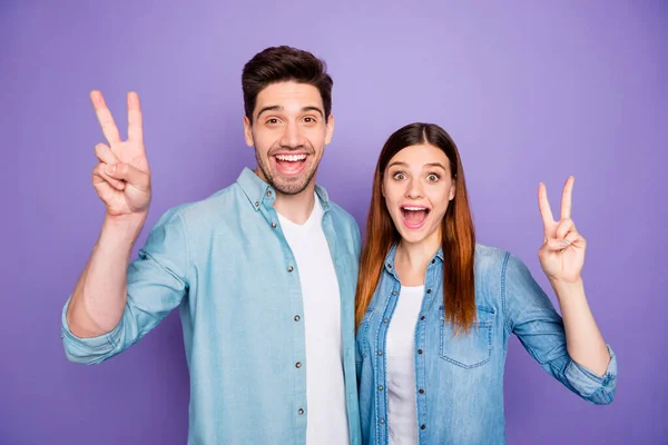 Retrato de casal romântico animado fazer v-sinais desfrutar de desgaste de caminhada jeans jeans roupa moderna isolado sobre fundo cor violeta — Fotografia de Stock