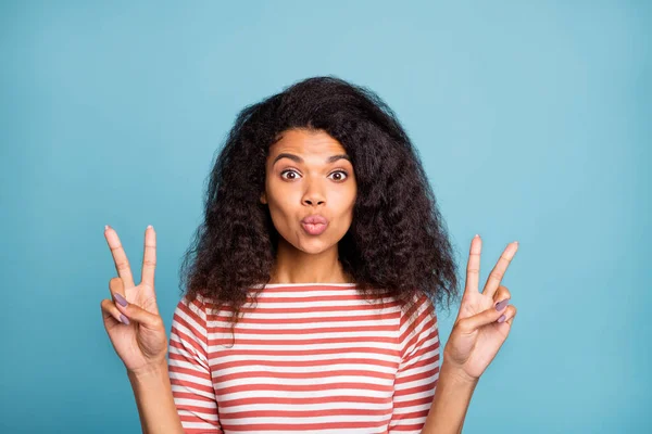 Retrato de cerca de agradable atractivo guapo guapo chica de pelo ondulado con jersey a rayas mostrando doble v-signo de envío de aire beso aislado en brillante brillo vivo vibrante fondo de color azul — Foto de Stock