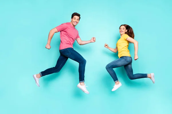 Pleine longueur profil taille du corps vue de côté de beau couple attrayant sportif joyeux courir sauter dans l'air en s'amusant vacances printemps isolé sur lumineux éclat vif fond vert turquoise vibrant — Photo