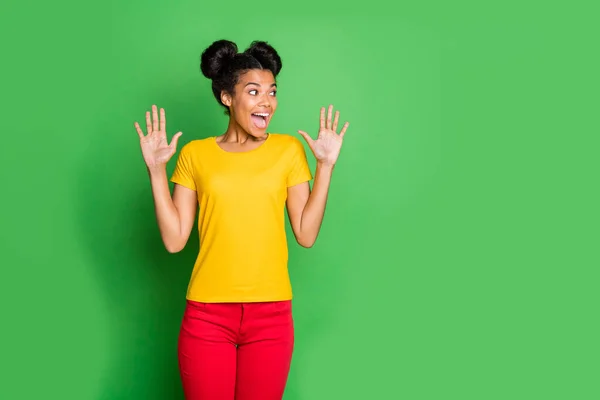 Photo of amazing dark skin lady looking placard on discount shopping prices not believe eyes wear casual yellow t-shirt and red pants isolated green background — Stock Photo, Image
