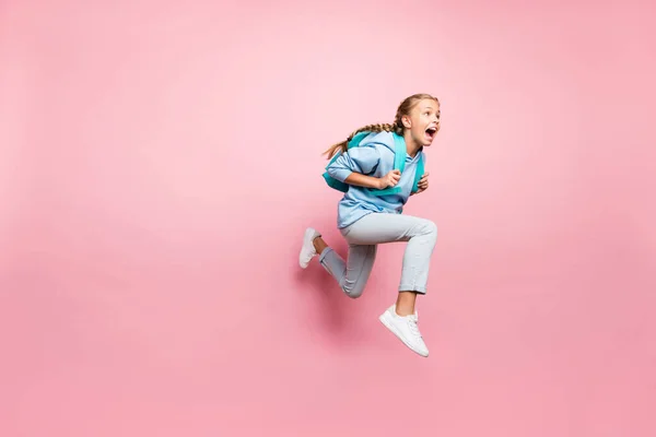 全身サイズになった写真の恐怖の少女逃げ恐怖でバックパックの後ろに身に着けている青スポーティな着用スウェットシャツとデニムパーカー隔離されたピンクのパステルカラー — ストック写真