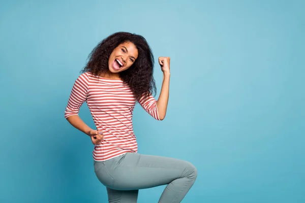 Photo of cheerful excited ecstatic cute nice shouting black woman wearing pants trousers rejoicing overjoyed about having won contests isolated over blue color vibrant background — Stock Photo, Image