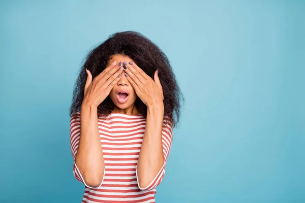 Foto di spaventata donna nera terrorizzata che si copre gli occhi dopo l'esame da oculista vicino allo spazio vuoto isolato su sfondo di colore blu vivido — Foto Stock